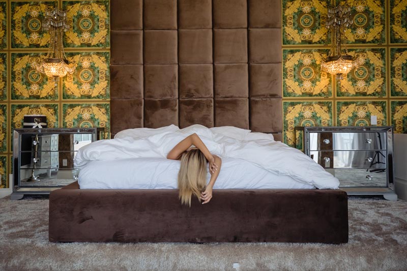 woman laying in brown velvet bed