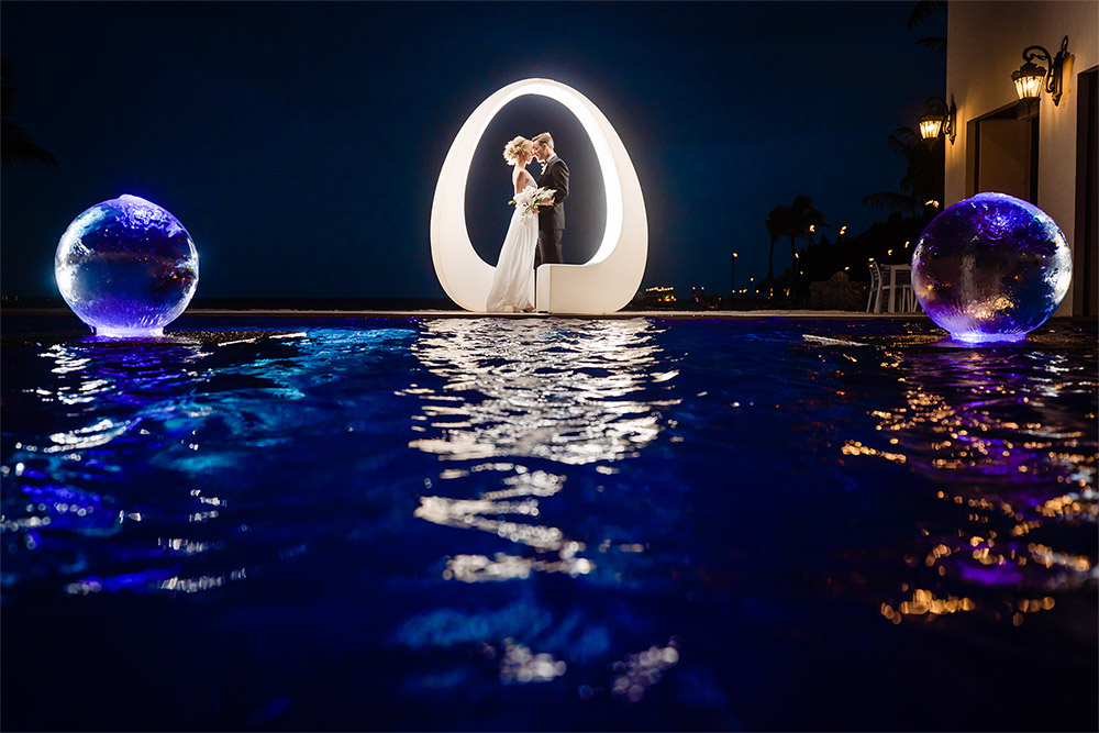 bride and groom posing by the pool